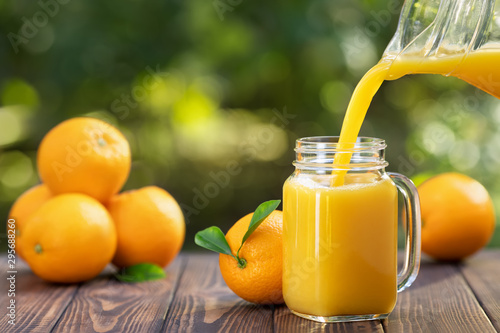 Bild auf Leinwand orange juice pouring in glass