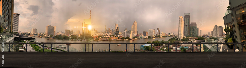 Paranamic view of Bangkok urban cityscape skyline night scene with empty loft cement floor on front.