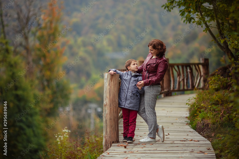 Travelers mother son in the autumn mountains for a walk. Travelers mother son in the autumn mountains for a walk.