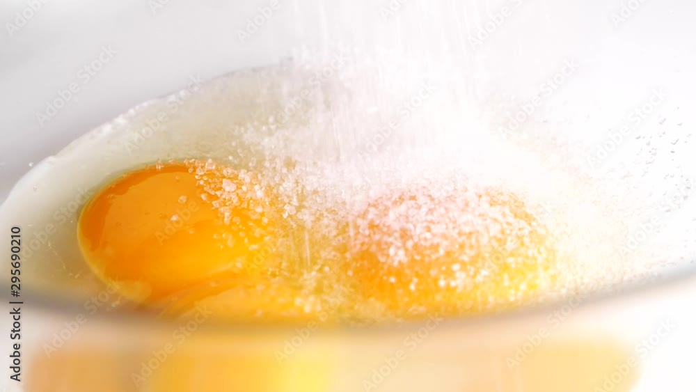 Sugar pouring in a glass bowl with eggs. Making breakfast. Slowmotion. Sugar pouring in a glass bowl with eggs. Making breakfast. Slowmotion.