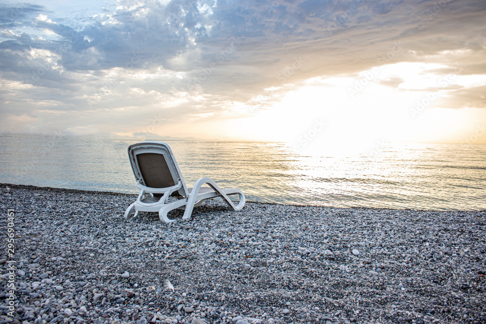 The summer season is over and only a lonely deck chair is left on the pebble beach. The summer season is over and only a lonely deck chair is left on the pebble beach.