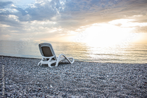 The summer season is over and only a lonely deck chair is left on the pebble beach. © Sergey