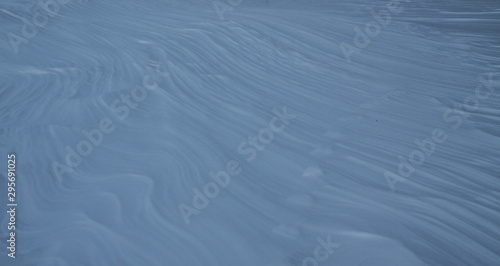 Snow-white snow and the earth sheltered by it. Countryside and snowfall. Winter dunes and mountains of snowflakes. Stock background.