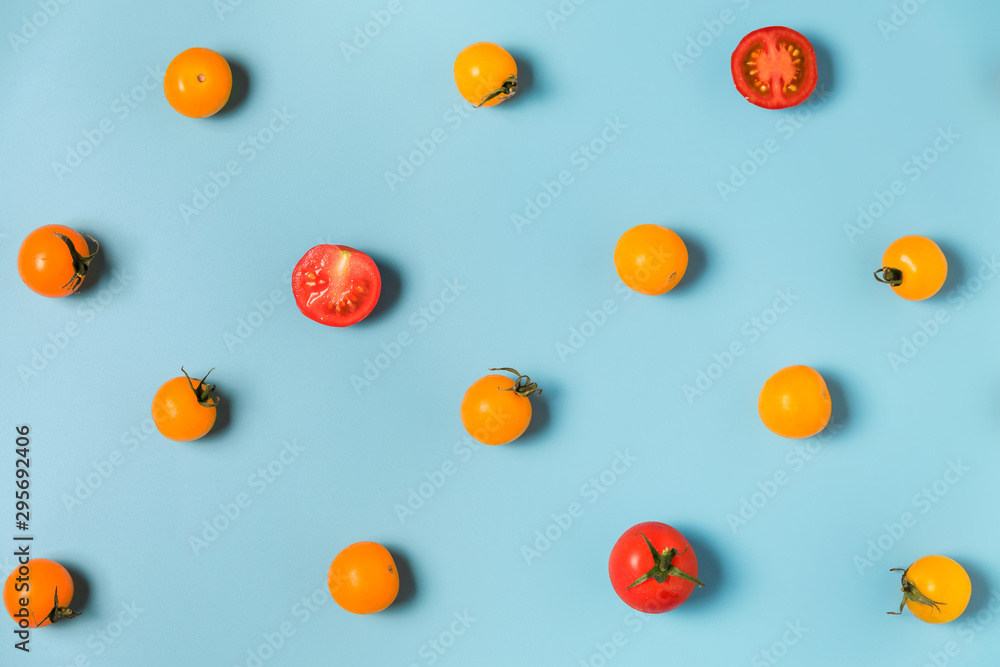Colorful pattern of yellow and red tomatoes on blue background. flat lay Colorful pattern of yellow and red tomatoes on blue background. flat lay