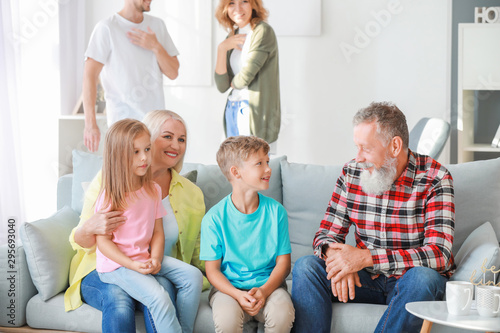 Grandparents with little children resting together at home