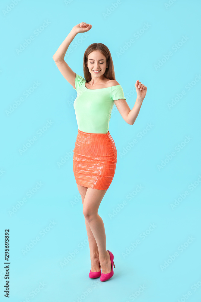 Naklejka premium Dancing young woman on color background