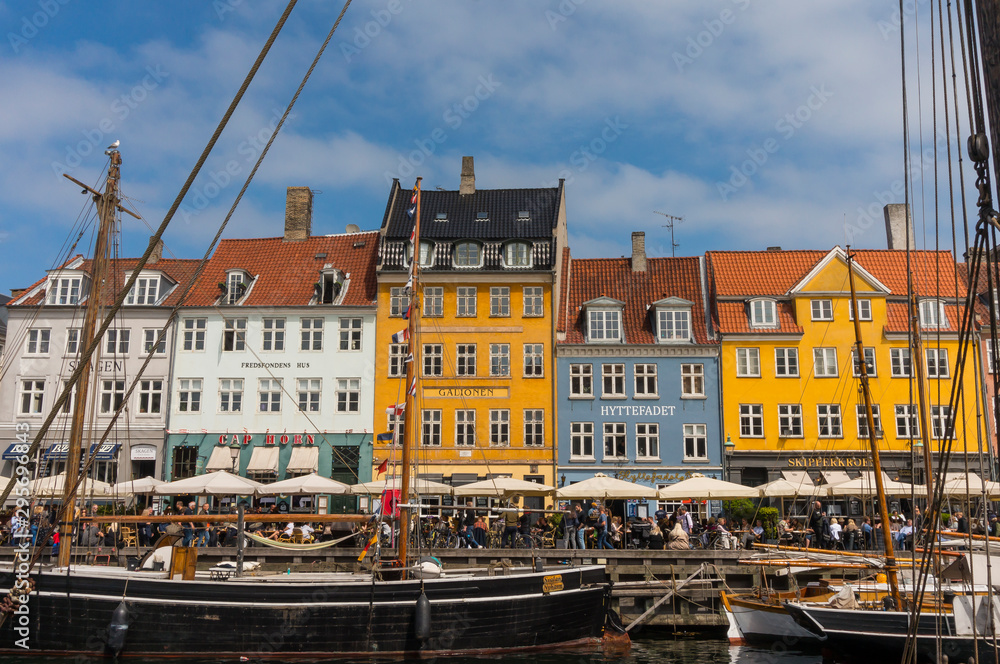 Famous Nyhavn pier with colorful facades of old houses and vintage ships in Copenhagen, capital of Denmark. Summertime in the fantastic city of Copenhagen