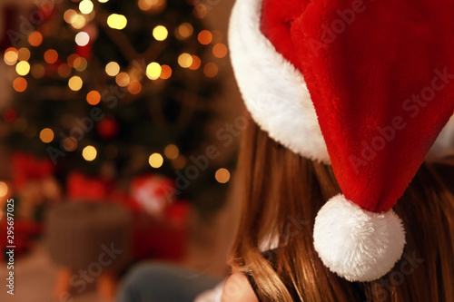 Young woman in Santa hat celebrating Christmas at home, closeup
