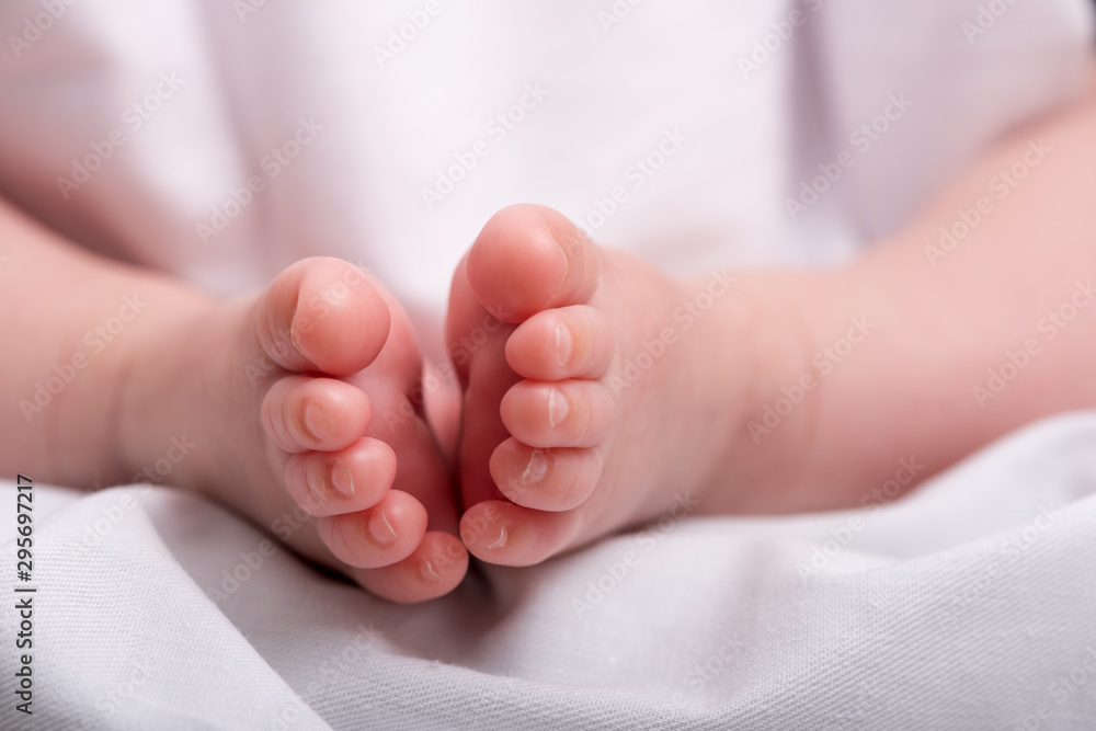 Newborn baby feet on a white blanket. Baby feet. Newborn baby feet on a white blanket. Baby feet.