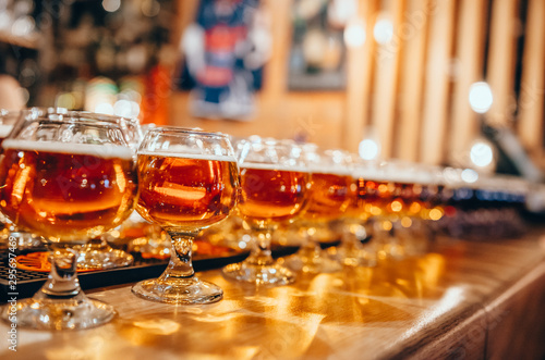 Glasses of light beer on wooden bar counter. Bar on background