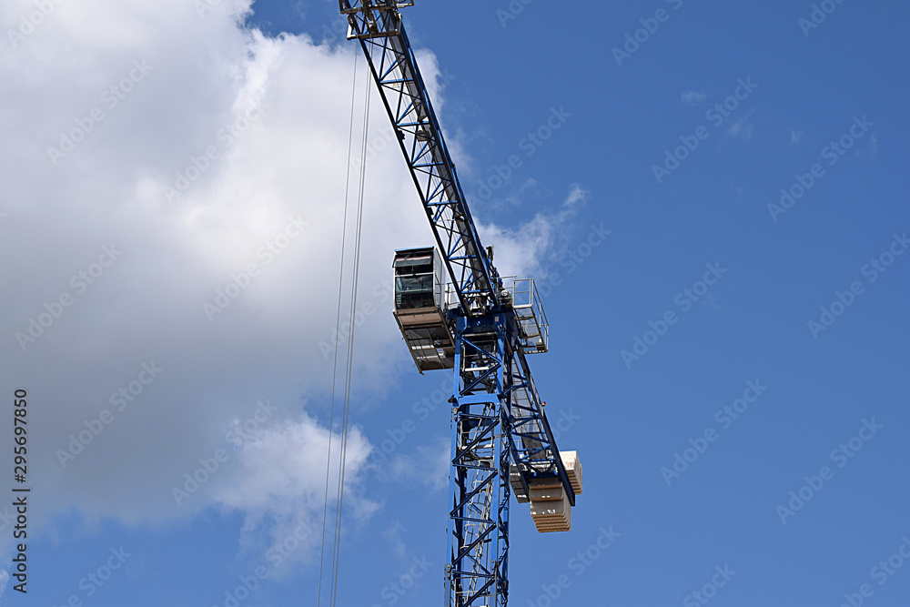 Tower crane with a cabin and an arrow on a background of the sky. Tower crane with a cabin and an arrow on a background of the sky.