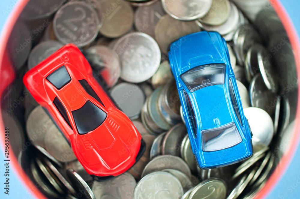 toy cars in a piggy Bank with coins, the concept of earning on cars