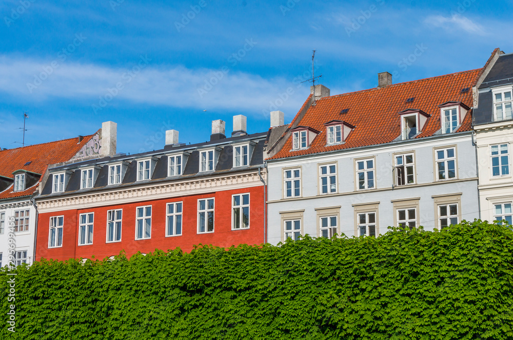 Scenic summer view of the ancient classic colorful houses with blue sky. Famous Nyhavn pier with colorful facades of old houses and vintage ships in Copenhagen, capital of Denmark