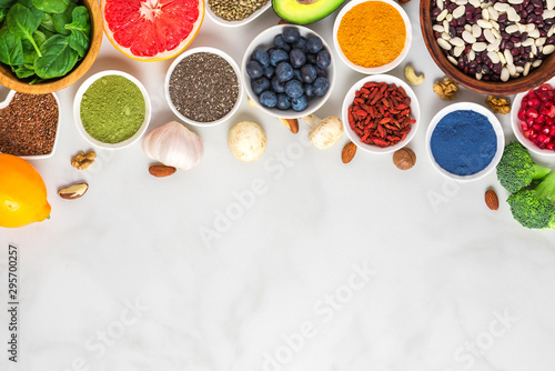 Healthy vegan food clean eating selection: fruit, vegetable, seeds, superfood, nuts, berries on white marble background photo