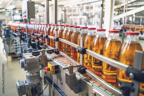 Photos Conveyor belt, juice in glass bottles on beverage plant or factory interior, ind
