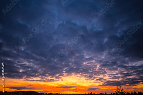 dramatic sunset over the prairies, dark dense clouds and red evening sun © Yuriy Kulik