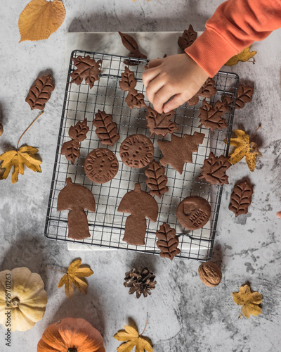 autumn chocolate cookies with kids hand, pumpkin and yellow leaves