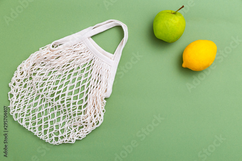 Mesh shopping bag on green background. BACK TO NATURE. Copy space