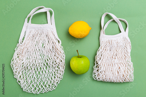 Mesh shopping bag with fruits on green canvas background. reusable concept. BACK TO NATURE