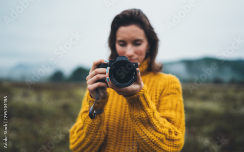 photographer girl hold in hands video camera take photo on background autumn foggy mountain, tourist shooting nature mist landscape, hobby concept © A_B_C