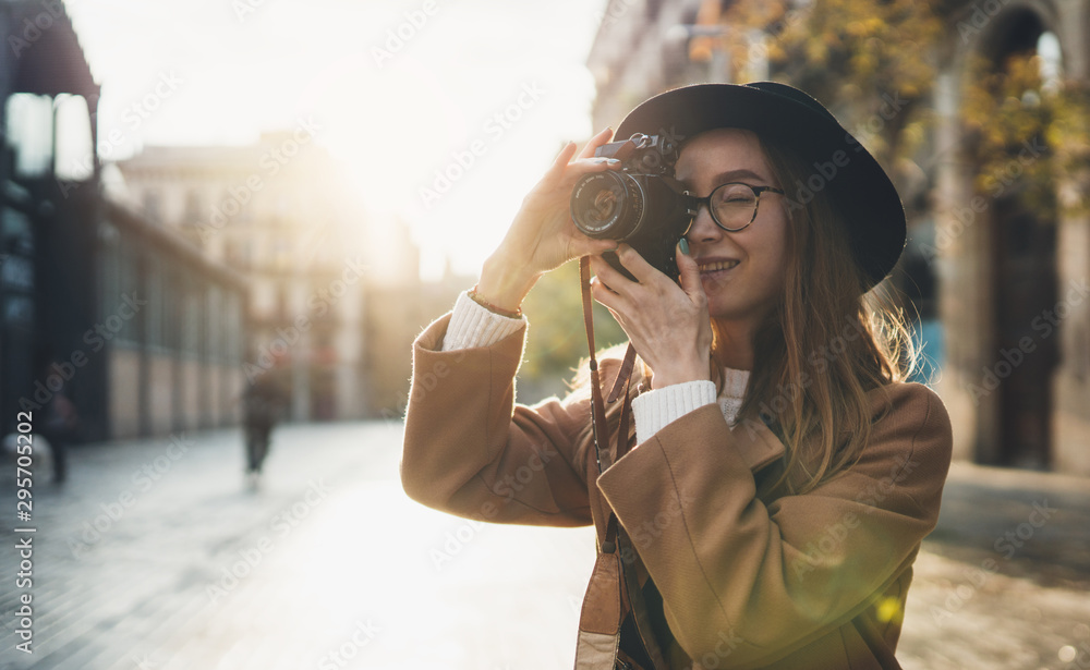 Photographer in glasses take photo camera. Tourist portrait. Girl in hat travels in Barcelona holiday. Sunlight flare street in europe city. Traveler hipster shooting architecture, copy space mockup