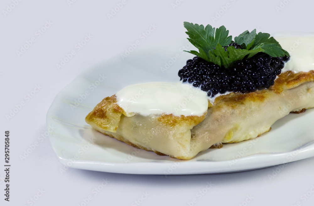 Stuffed pancake with black caviar and sour cream. Stuffed pancake with black caviar and sour cream.