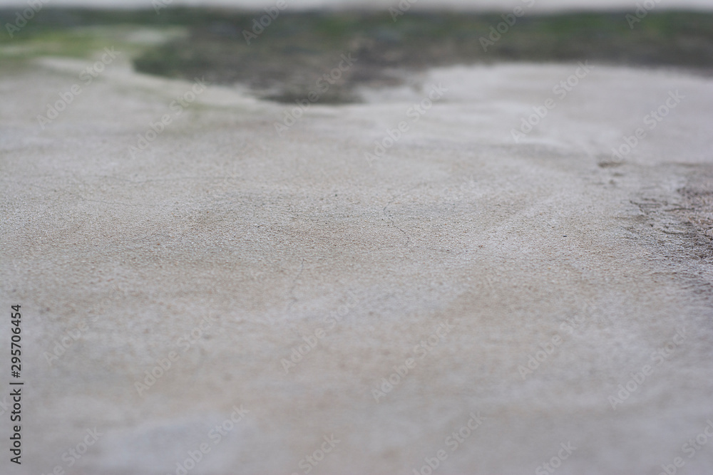 Background with a stone surface shot at an angle with a very small depth of field and a very blurred foreground and background Background with a stone surface shot at an angle with a very small depth of field and a very blurred foreground and background