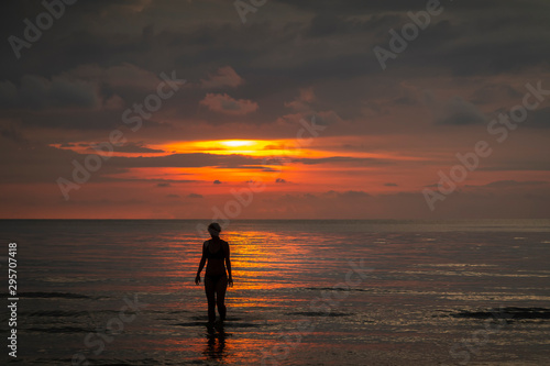 standing in the asian sea at sunset