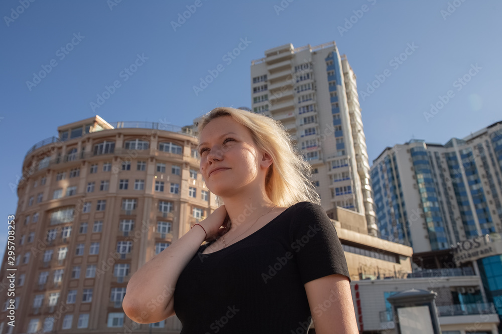 Blonde girl on the background of high-rise buildings