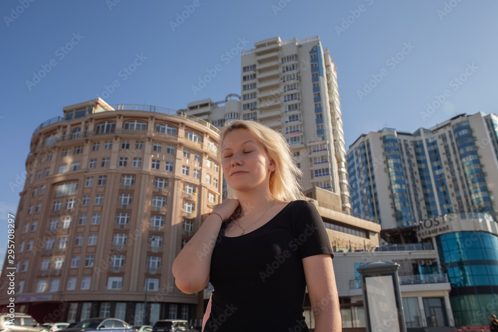 Blonde girl on the background of high-rise buildings