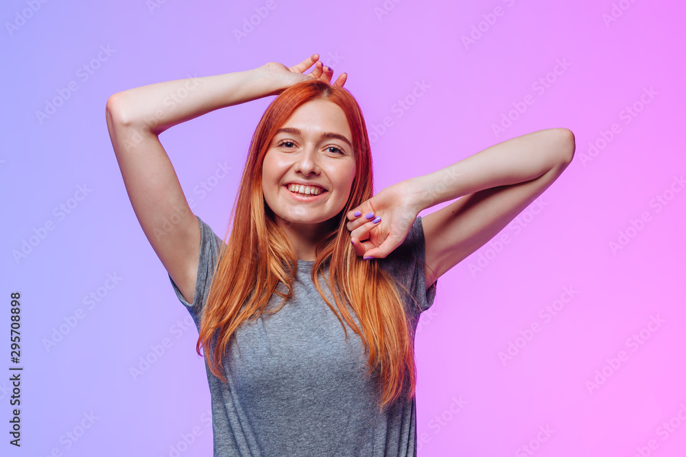 Fototapeta premium Redhead girl posing and smiling on pink blue background