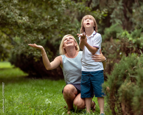 Affectionate young mother and her challenged kid feeling the first rain drops in a summer park