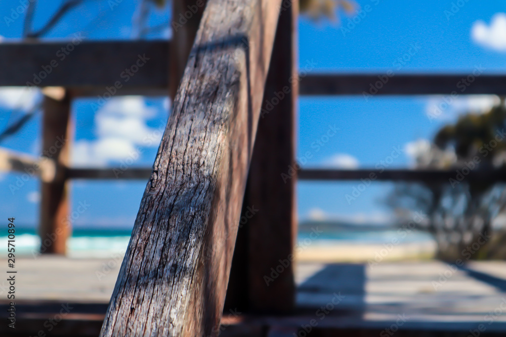 Fototapeta premium Close-up of a wooden handrail in a clear day at the beach