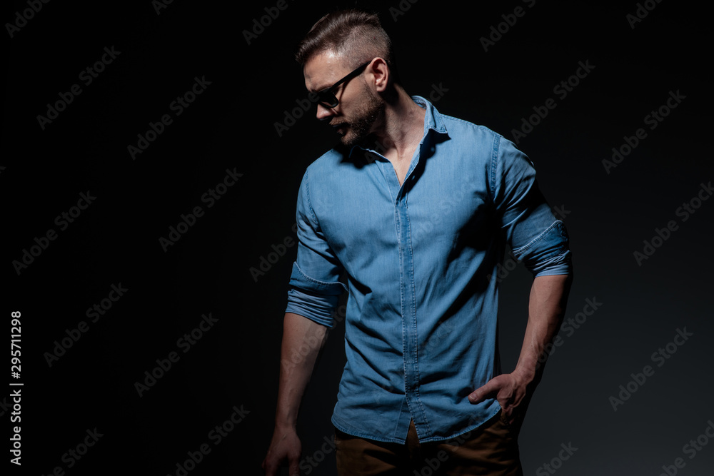 casual man standing with hand in pocket and looking down casual man standing with hand in pocket and looking down
