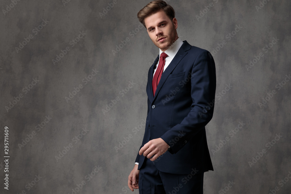 Serious looking businessman walking and wearing an elegant blue suit Serious looking businessman walking and wearing an elegant blue suit