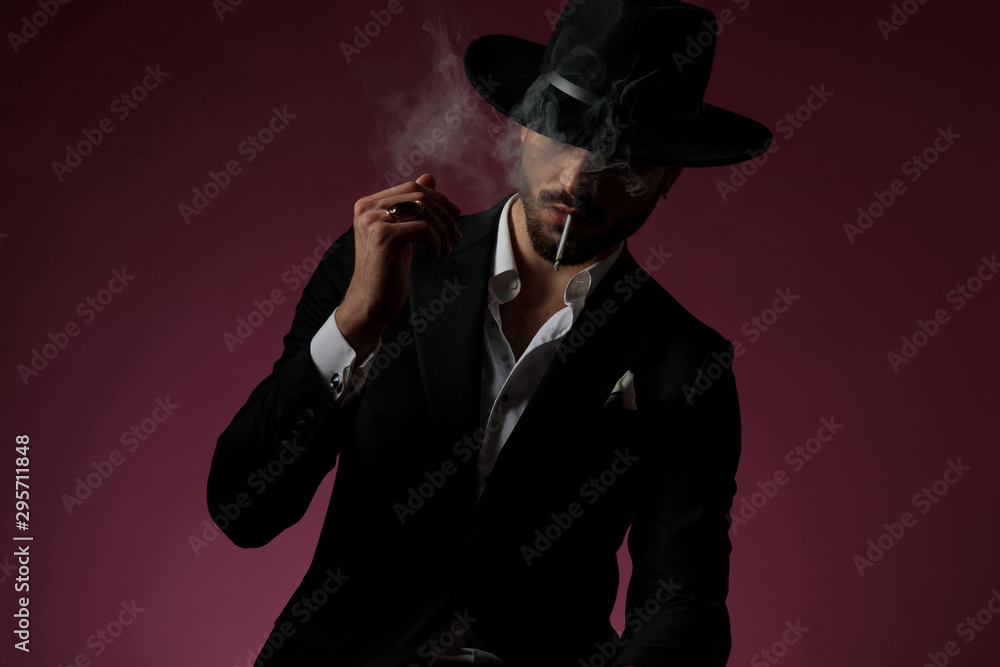 Confident man looking away, smoking and thinking Confident man looking away, smoking and thinking