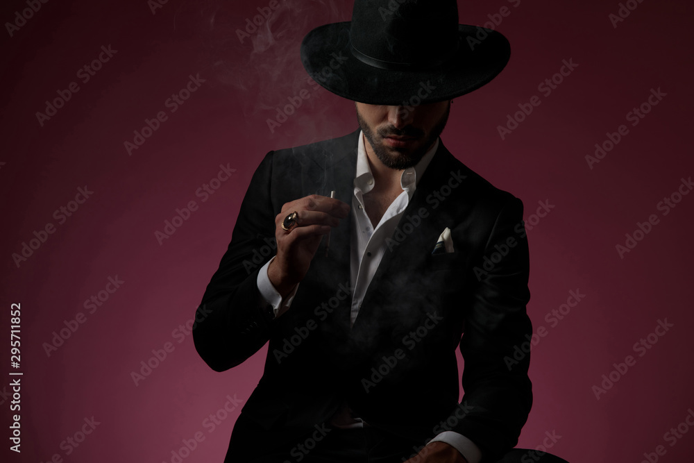 Serious looking mysterious man smoking a cigarette