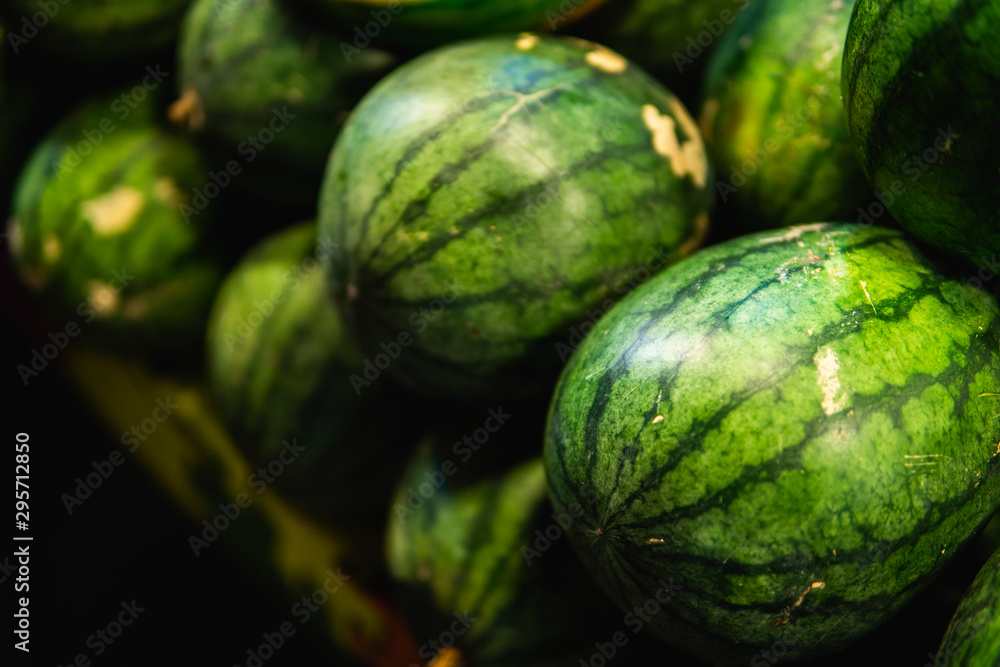 Ripe and sweet watermelons in the market. Close up. A lot of large ripe green striped watermelons. Organic farmer market, store. Ripe and sweet watermelons in the market. Close up. A lot of large ripe green striped watermelons. Organic farmer market, store.