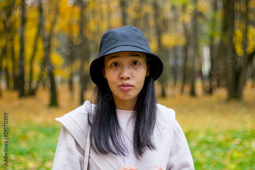 Asian girl in black hat in the autumn park