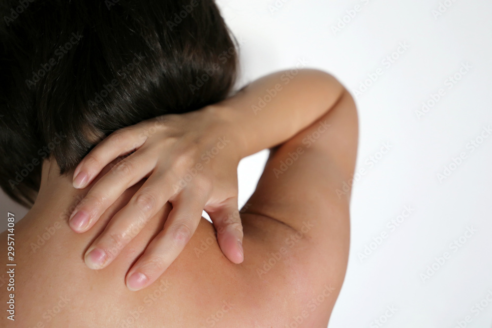 Neck pain, woman clutched by hand her shoulder, back view. Concept of the spine injury, clavicle and medical massage