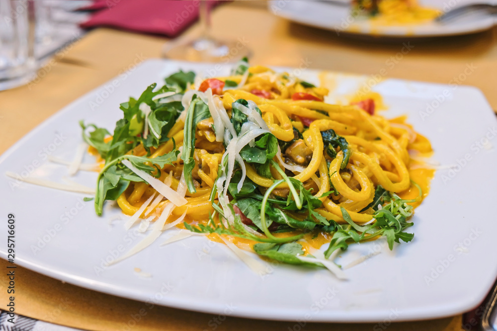 Italian pasta with vegetables, pumpkin and arugula, close up shot Italian pasta with vegetables, pumpkin and arugula, close up shot