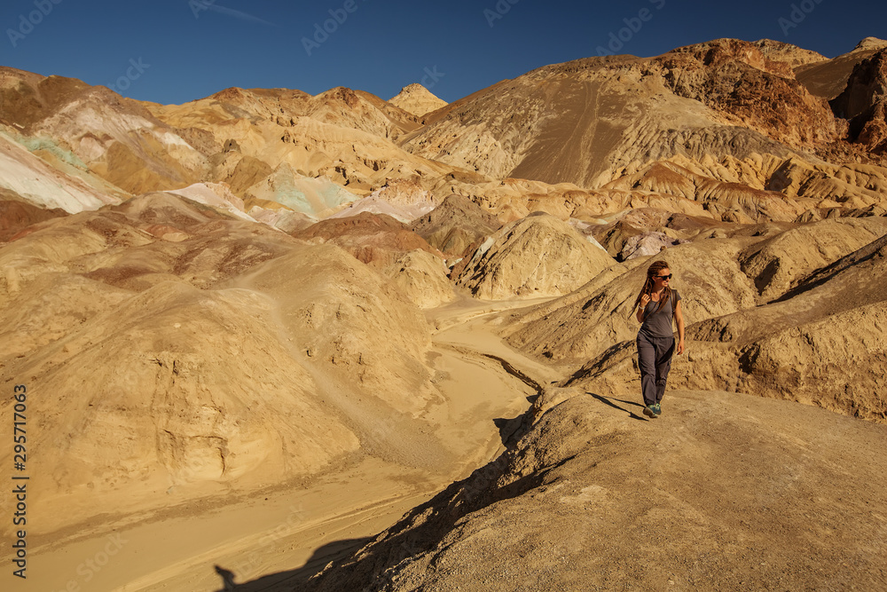 A hiker in the Artist`s Palette landmark place in Death Valley National Park, Geology, sand. A hiker in the Artist`s Palette landmark place in Death Valley National Park, Geology, sand.