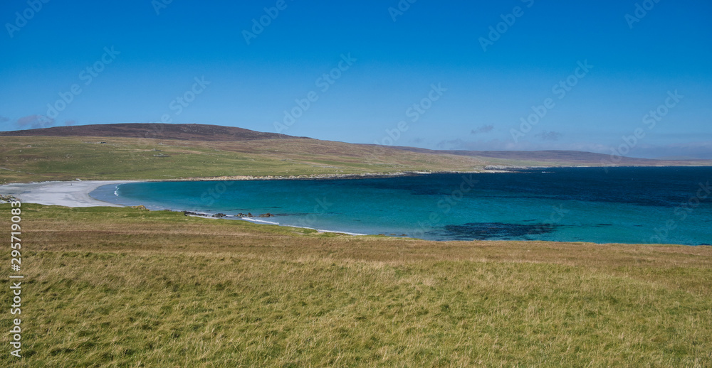 The white sand and blue sea at Sandwick on the island of Unst in Shetland, Scotland, UK - an idyllic, unspoiled, remote beach.