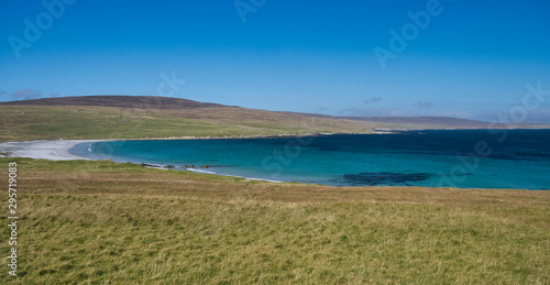 The white sand and blue sea at Sandwick on the island of Unst in Shetland, Scotland, UK - an idyllic, unspoiled, remote beach.