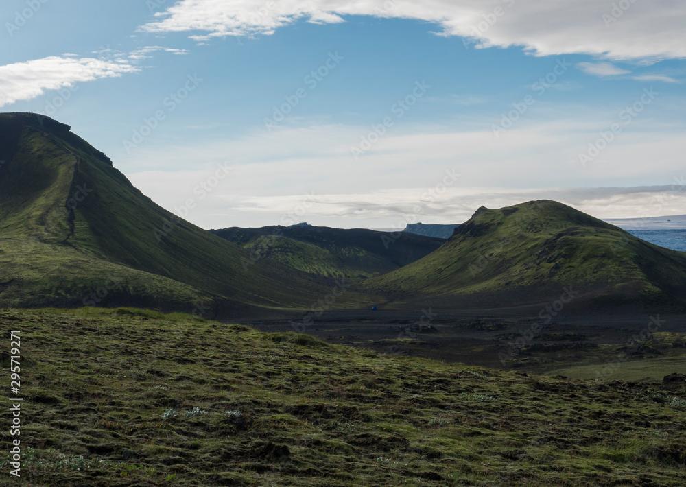 Obraz premium Volcanic landscape with blue container,Tindfjallajokull glacier, green hills and lava gravel ground covered by grass and moss. Fjallabak Nature Reserve, Iceland