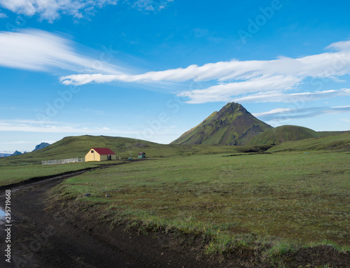 Ancient farm houses near the Hvanngil camp site with green storasula montain onLaugavegur hiking trail, Highlands of Iceland