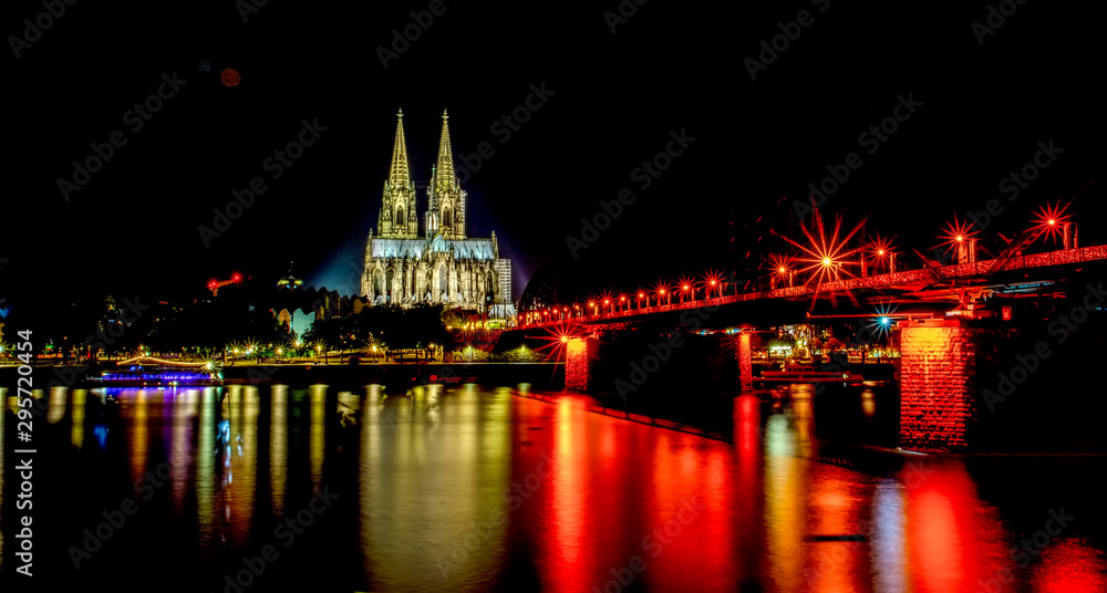 Night View of Cologne Cathedral (Kolner Dom) and Rhine river under the Hohenzollern Bridge, Cologne city skyline at night, North Rhine Westphalia region, Germany.