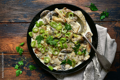 Chicken stewed with mushrooms and leek in a cream sauce. Top view with copy space.