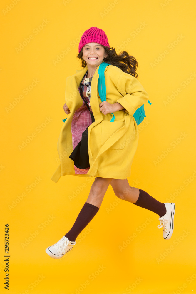 Tread on air. Active small child rush to school on yellow background. Happy girl enjoy active lifestyle. Little schoolchild feel active in autumn. Active and energetic Tread on air. Active small child rush to school on yellow background. Happy girl enjoy active lifestyle. Little schoolchild feel active in autumn. Active and energetic