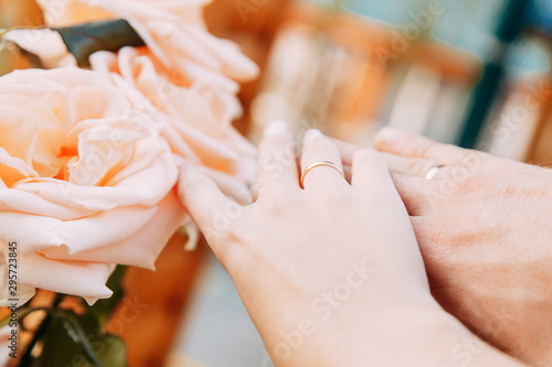 wedding rings on hand with pink wedding bouquet